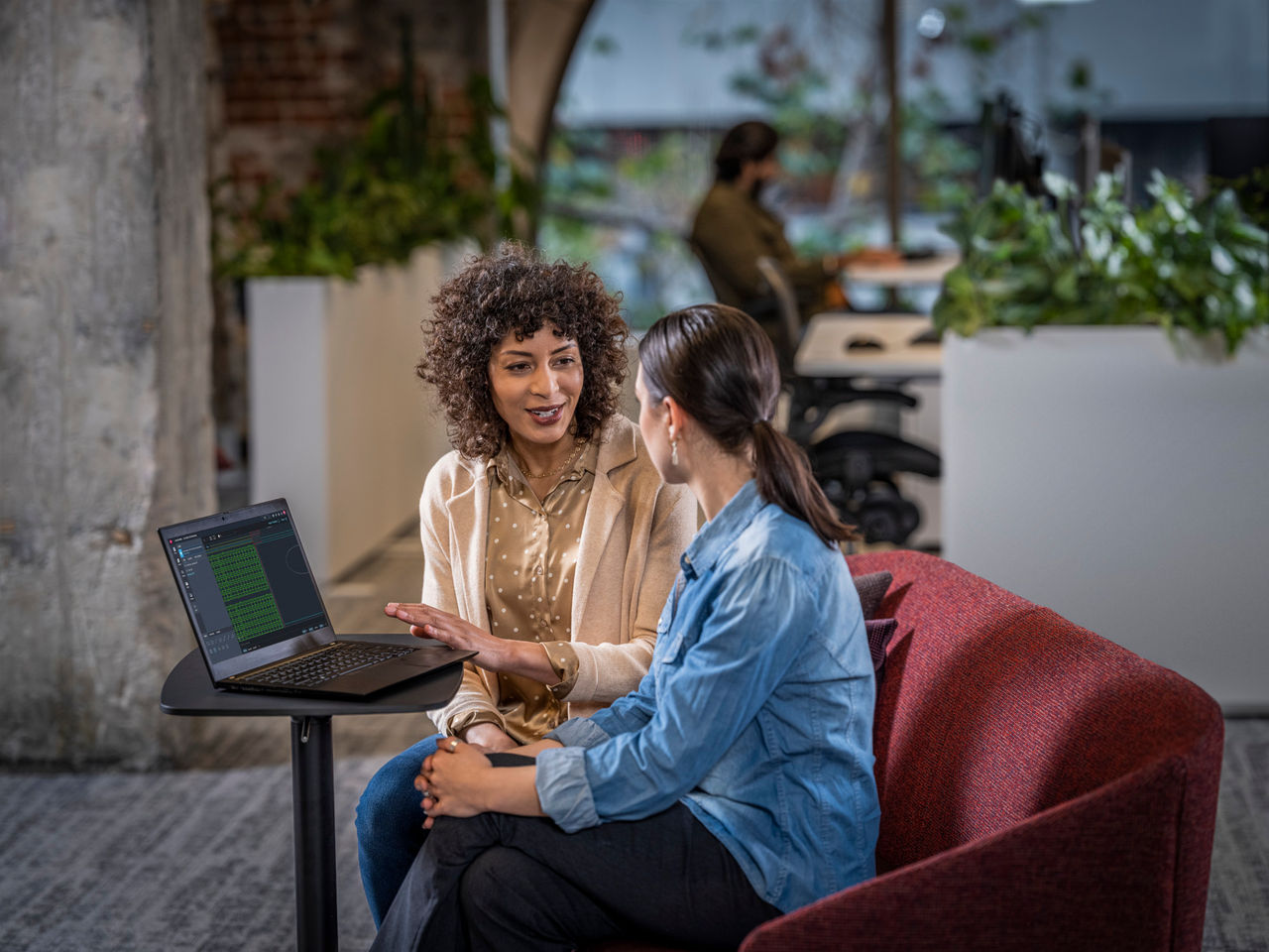 Women collaborating and using AutoCAD on a laptop in an office environment.